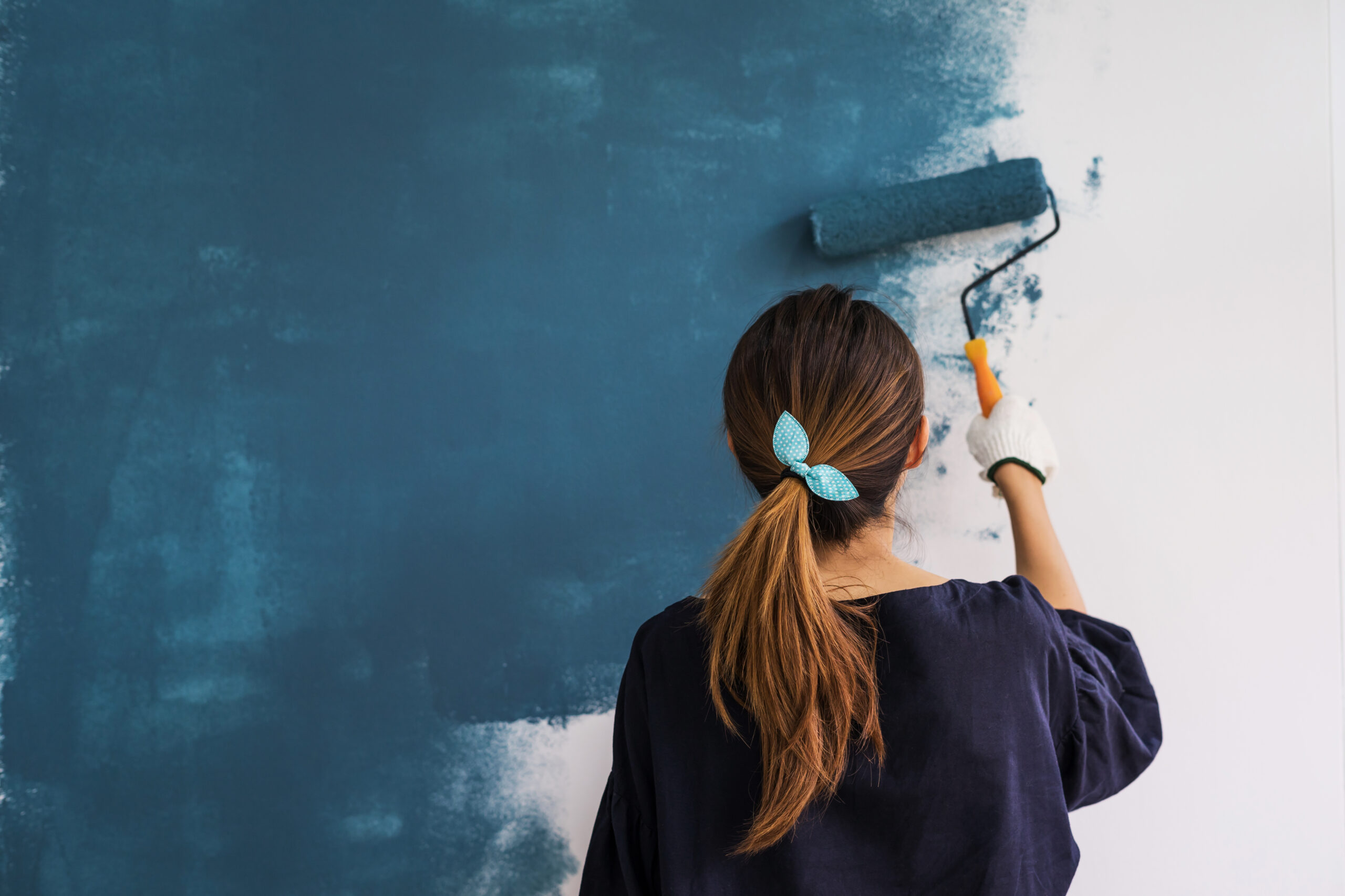 Women painting the interior of her home.